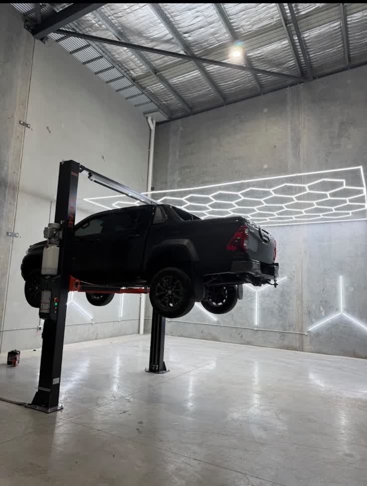 Vehicle raised on the two-post hoist inside the Axie Autoworks workshop